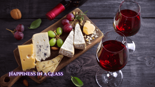 2 glasses of red wine next to a board with cheese and grapes