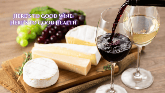 Glass of wine being poured next to cheese and grapes